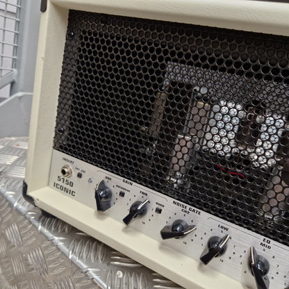 Pre-Owned EVH 5150 Iconic 80W Electric Amplifier Head A close-up shot of a Korg 5150 guitar amplifier head, showing the cream-colored front faceplate, black honeycomb speaker grille, and control knobs on a silver diamond plate surface.