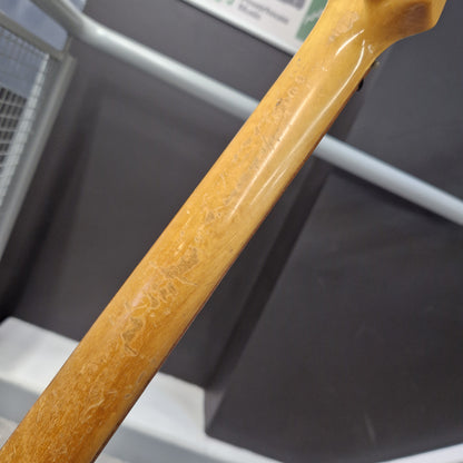 Pre-Owned Hagstrom Futurama Deluxe 1960s Bass - Red Close-up of a light natural wood guitar neck with visible wear, scratches, and faded serial number engravings, set against a dark gray background.