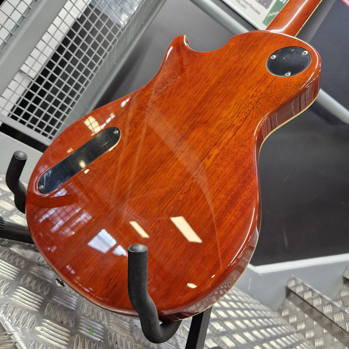 Pre-Owned PRS SE Bernie Marsden Signature Electric - Vintage Sunburst Close-up of the glossy reddish-brown wooden body of an electric guitar resting on a display stand.