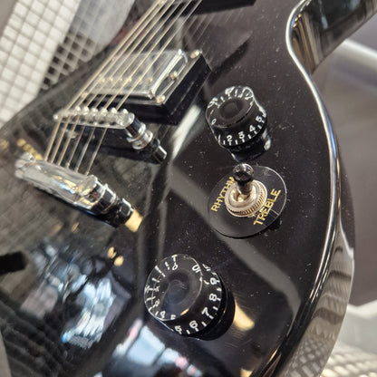 Pre-Owned Marshall MGAP Singlecut Electric - Black Gloss Close-up of a glossy black electric guitar body showing the volume, treble, and rhythm control knobs, bridge, and part of the neck with clear strings.