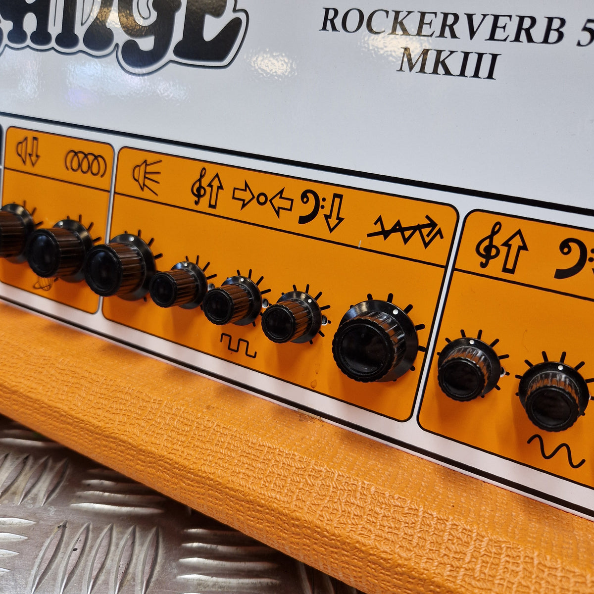 Pre-Owned Orange Rockerverb 50H MKIII Valve Electric Amplifier Head Close-up of a guitar headstock control panel with orange and white sections, black knobs, and printed text including 'ROCKERVERB 5 MKIII' and a visible Focal brand logo.