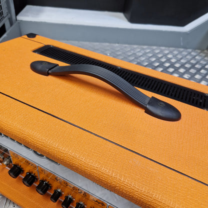 Pre-Owned Orange Rockerverb 50H MKIII Valve Electric Amplifier Head Close-up of an orange textured amplifier cabinet with a black carrying handle, vent grille, and control knobs.