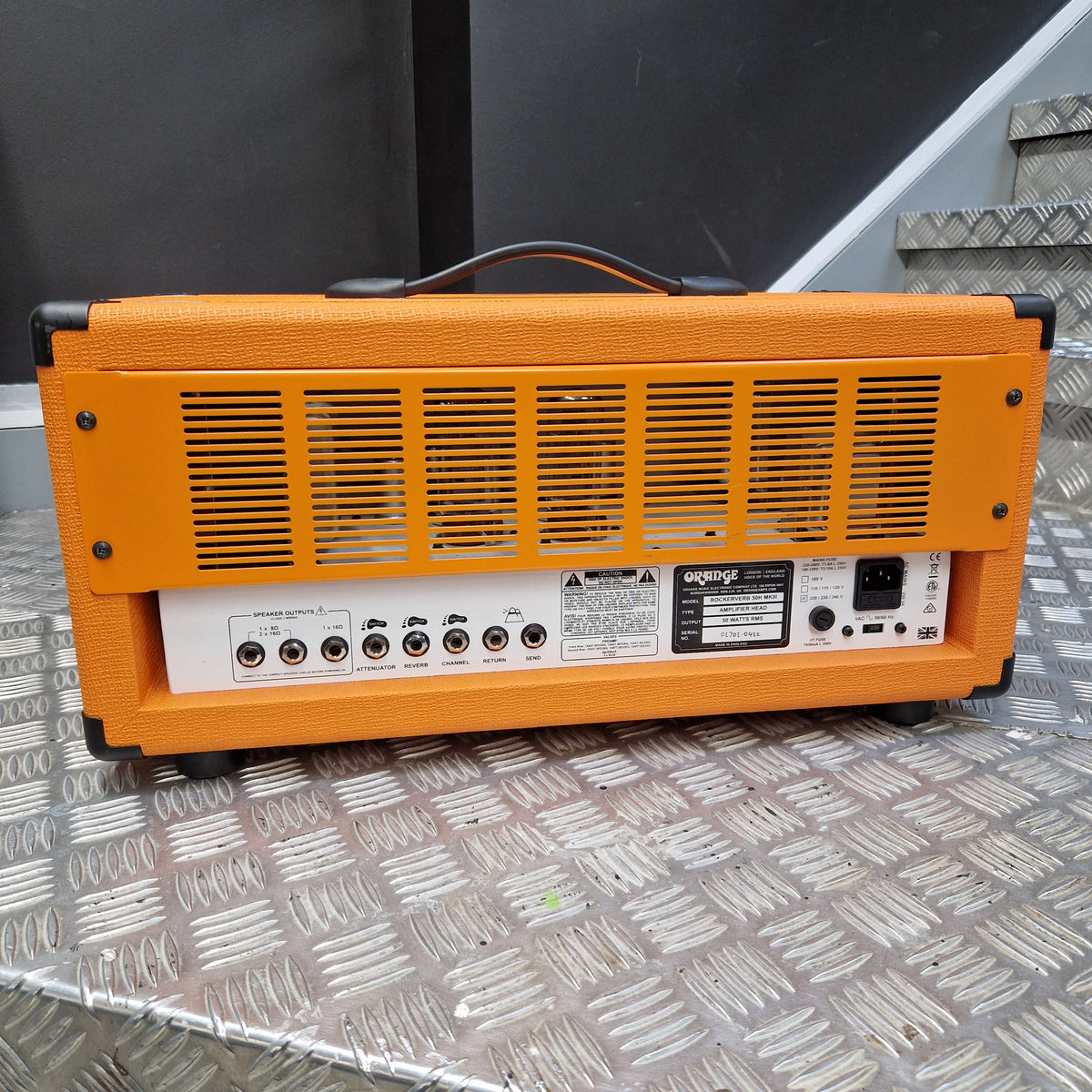 Pre-Owned Orange Rockerverb 50H MKIII Valve Electric Amplifier Head An orange and black guitar amplifier shown from the back, resting on a diamond plate metal surface.