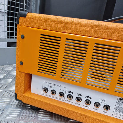 Pre-Owned Orange Rockerverb 50H MKIII Valve Electric Amplifier Head Close-up of the rear panel of an orange guitar amplifier, showing ventilation grilles, control knobs, and a white label on a textured orange cabinet.