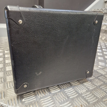 Pre-Owned Blackstar HT Club 50 Electric All-Valve Amplifier Head A black textured faux-leather or leather-bound notebook, binder, or case with metal corner rivets, shown from a top-down angle on a silver diamond plate metal surface.