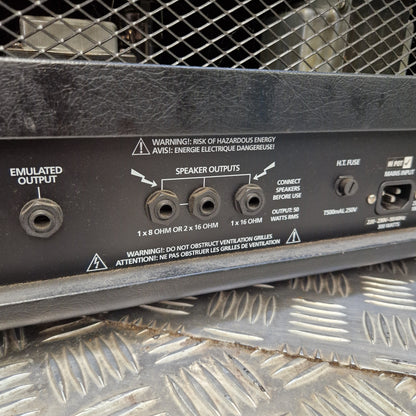 Pre-Owned Blackstar HT Club 50 Electric All-Valve Amplifier Head Close-up of a black speaker amplifier control panel with speaker outputs, jacks, and warning labels, photographed next to a diamond plate metal surface.
