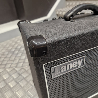 Pre-Owned Laney LG20R 20w Electric Guitar Combo Close-up of a black textured Laney speaker cabinet corner with a glossy black handle and a silver Laney logo badge on a perforated grille.