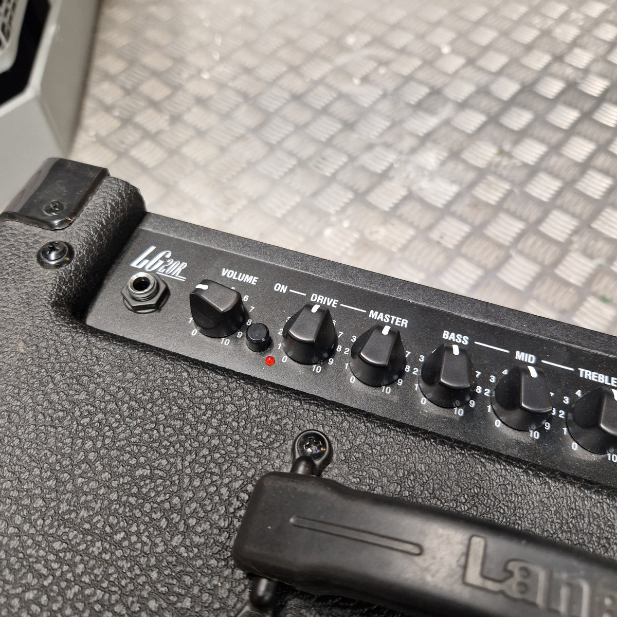 Pre-Owned Laney LG20R 20w Electric Guitar Combo Close-up of a black guitar amplifier control panel with knobs labeled Volume, Drive, Master, Bass, and Throttle, mounted on a textured black amplifier body.