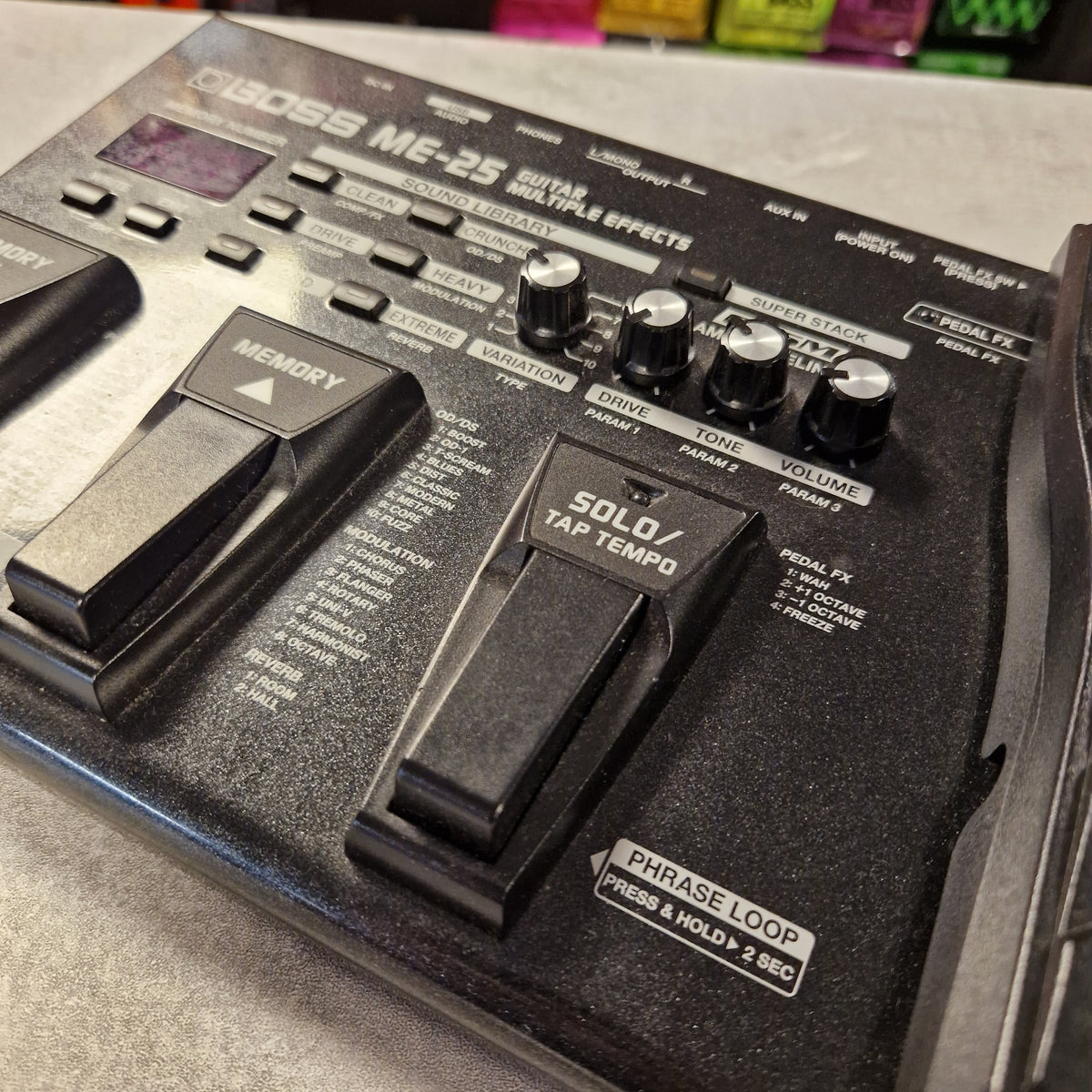 Pre-Owned Boss ME-25 Multi-Effects Pedal A close-up of a Boss MF-35 effects pedal unit in black, showing knobs, footswitches, and labels including 'SOLID TP tempo' and 'PHASE LOOP'.