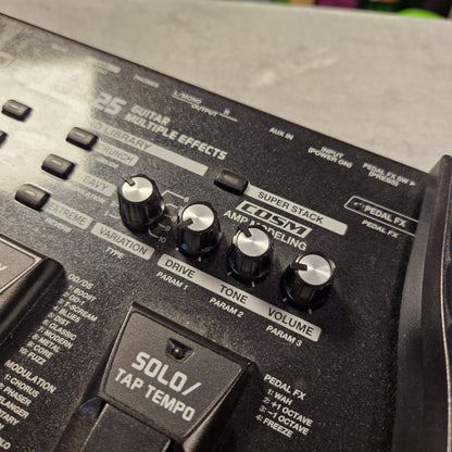 Pre-Owned Boss ME-25 Multi-Effects Pedal Close-up of a black Fender Solo/Tap Tempo multi-effects guitar pedal control panel with silver and black knobs, including Superstak, Amp Modeling, Volume, Tone, Drive, and FX Send.