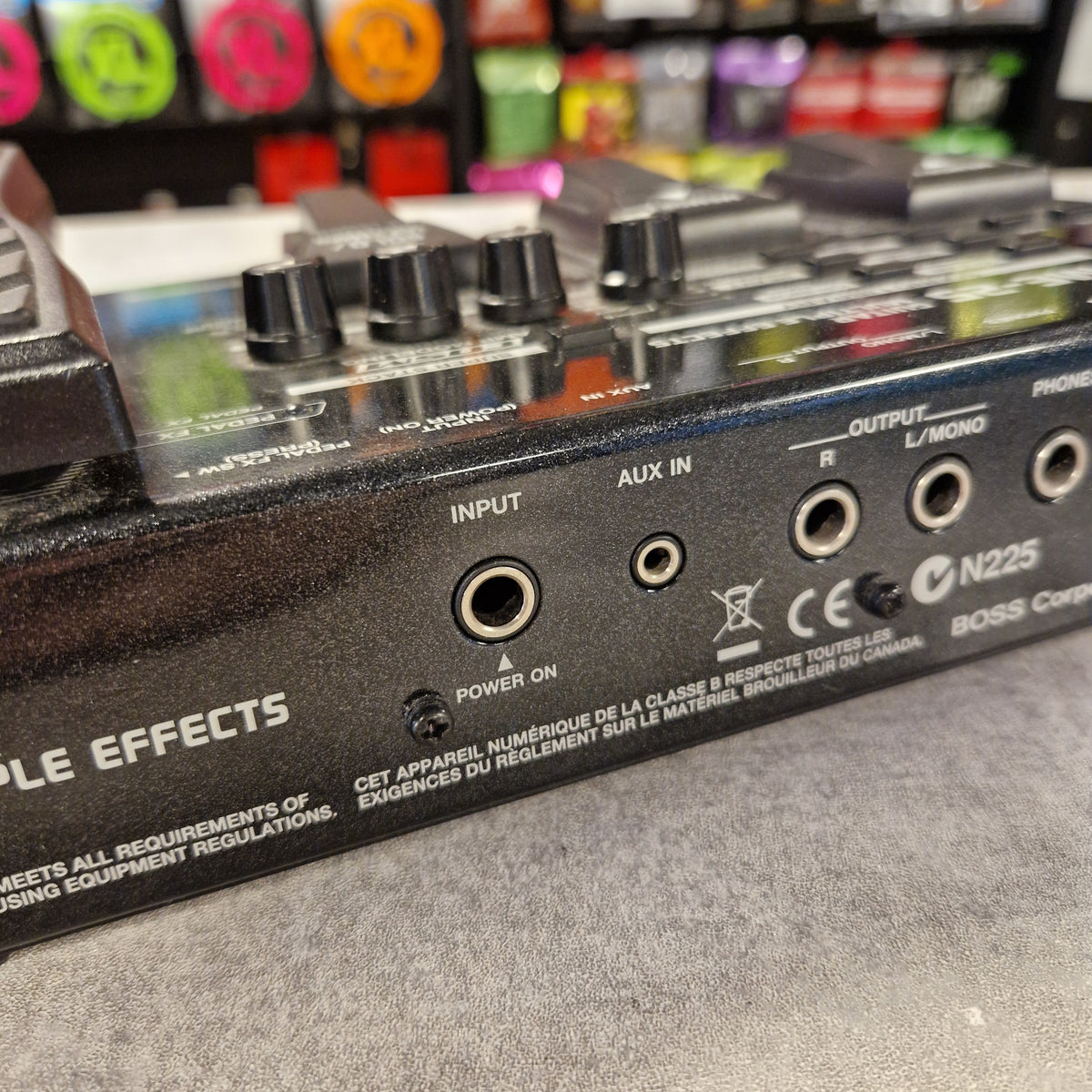 Pre-Owned Boss ME-25 Multi-Effects Pedal Close-up of the rear panel of a black audio effects pedal or multi-effects unit, showing input and output jacks, knobs, and printed labels including 'NOISE GATES' and 'N225'.