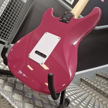 Pre-Owned PRS SE Silver Sky John Mayer Signature Electric - Dragonfruit w/ Gig Bag - A close-up of the back of a pink electric guitar body with a white pickguard and black hardware, photographed indoors against a dark and metallic background.