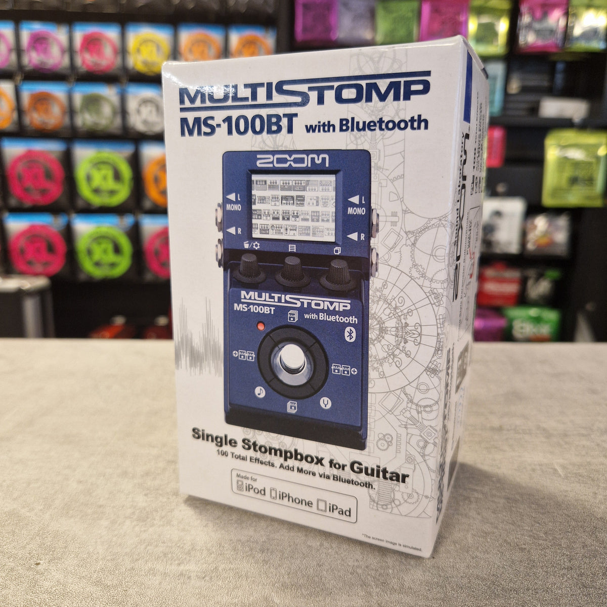 Pre-Owned Zoom MS-100BT MultiStomp Guitar Pedal with Bluetooth - A boxed product labeled 'MULTISTOMP NS-100BT with Bluetooth' and 'Single Skopbox for Guitar' shown on a retail store shelf. The box features a photo of a blue multi-voice guitar effects pedal on the front.