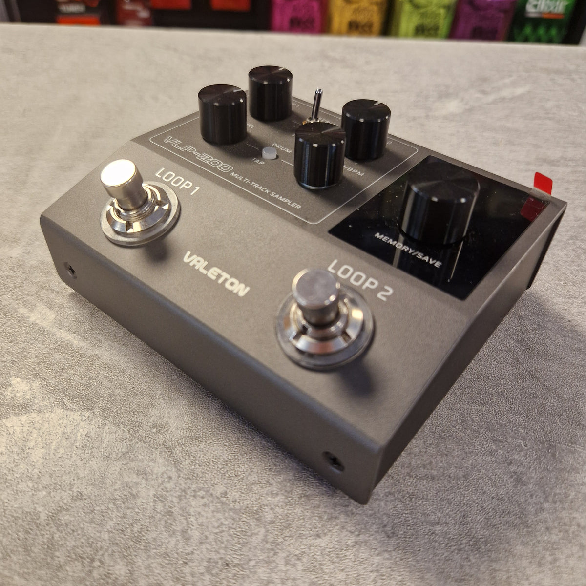 Pre-Owned Valeton VLP-200 Multi-Track Sampler w/ Box - A Valjeton VSP19000 multi-track sampler loop pedal in dark gray metal with black knobs, silver footswitches, and white printed labels, resting on a gray textured surface.