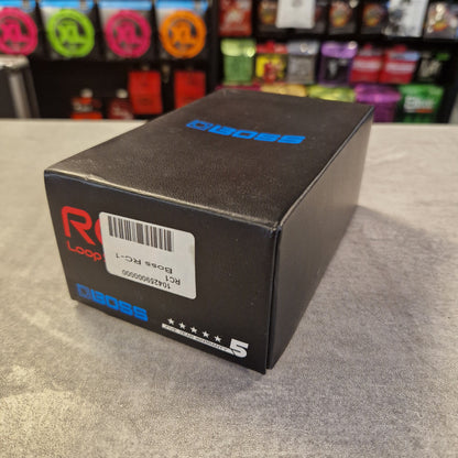 Pre-Owned Boss RC-1 Looper Pedal w/ Box A black rectangular product box with blue and red Diags branding, photographed on a gray textured surface with a blurred store shelf in the background.