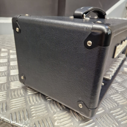 Pre-Owned Blackstar HT-5RH 5w Electric Amplifier Head w/ Footswitch - Close-up of the bottom corner of a black textured guitar amplifier, showing the corner protectors and handle attachment, resting on a silver diamond plate metal surface.