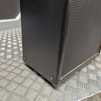 Pre-Owned Blackstar HT-112 1x12 Electric Amplifier Cab - Close-up of a black speaker cabinet corner with a metal mesh grille, photographed on a diamond-plate metal surface.