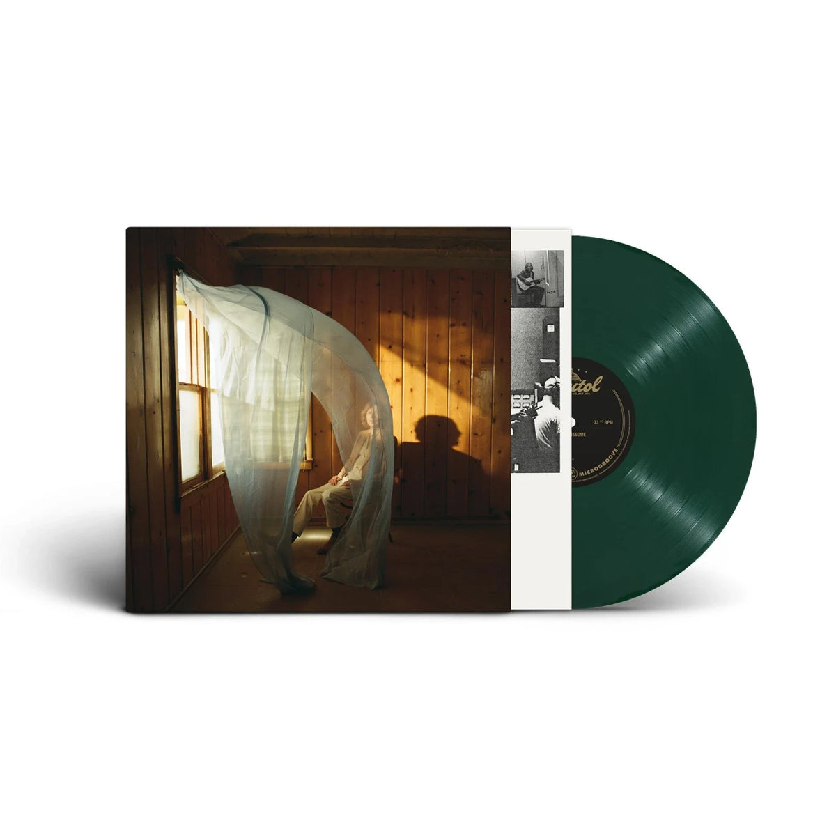 Beck - Ride Lonesome (Dark Green) Vinyl A vinyl record partially pulled from its sleeve, showing a dark green record and the album cover art with a seated figure in a warmly lit room.
