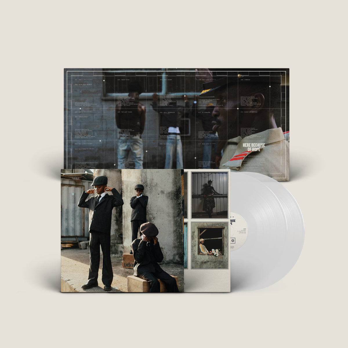 Ezra Collective - Here Because of Hope (Translucent White) Vinyl A vinyl record album package shown on a light warm-gray background. The front cover features a collage of street-style photographs with people in dark clothing, and a translucent clear vinyl record is partially visible behind the sleeve.