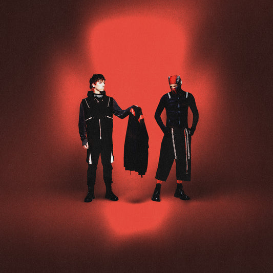 Twenty One Pilots - Breach Two people in black outfits with a red light on a dark background