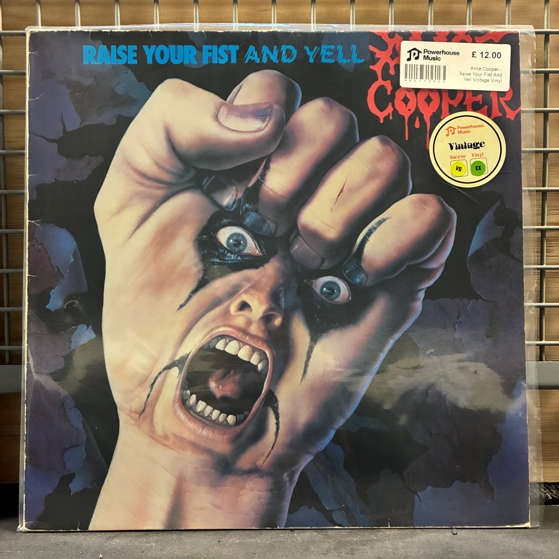 Alice Cooper Vinyl record cover with a hand holding a fist and screaming face, featuring a vintage label.