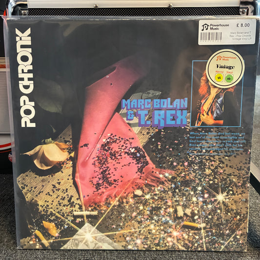 Marc Bolan and T. Rex - Pop Chronik Vintage Vinyl LP A vinyl record album cover for Marc Bolian & T. Rex's 'Pop Chronic' is shown in its shrink wrap on a black equipment case.