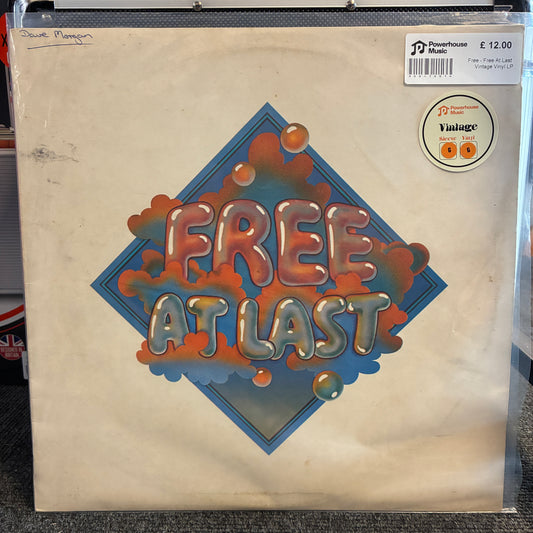 Free - Free At Last Vintage Vinyl LP A vinyl record sleeve for David Pympton's 'Free At Last' on PJ Records, sealed in a clear protective plastic sleeve. The cover features a retro, 1970s-style design with the title in 3D metallic bubble letters over a blue diamond shape with orange and blue abstract cloud-like splatters on a cream-colored background.