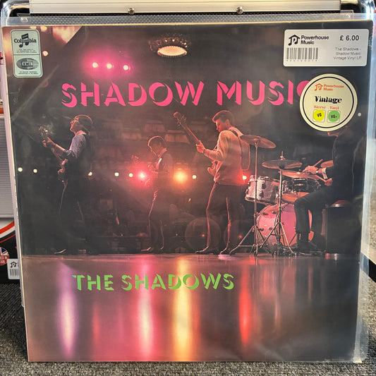 The Shadows - Shadow Music Vintage Vinyl LP The Shadows 'Shadow Music' vinyl record LP in a clear plastic protective case, featuring a stage performance photo with pink title text and a Powerhouse Records logo.