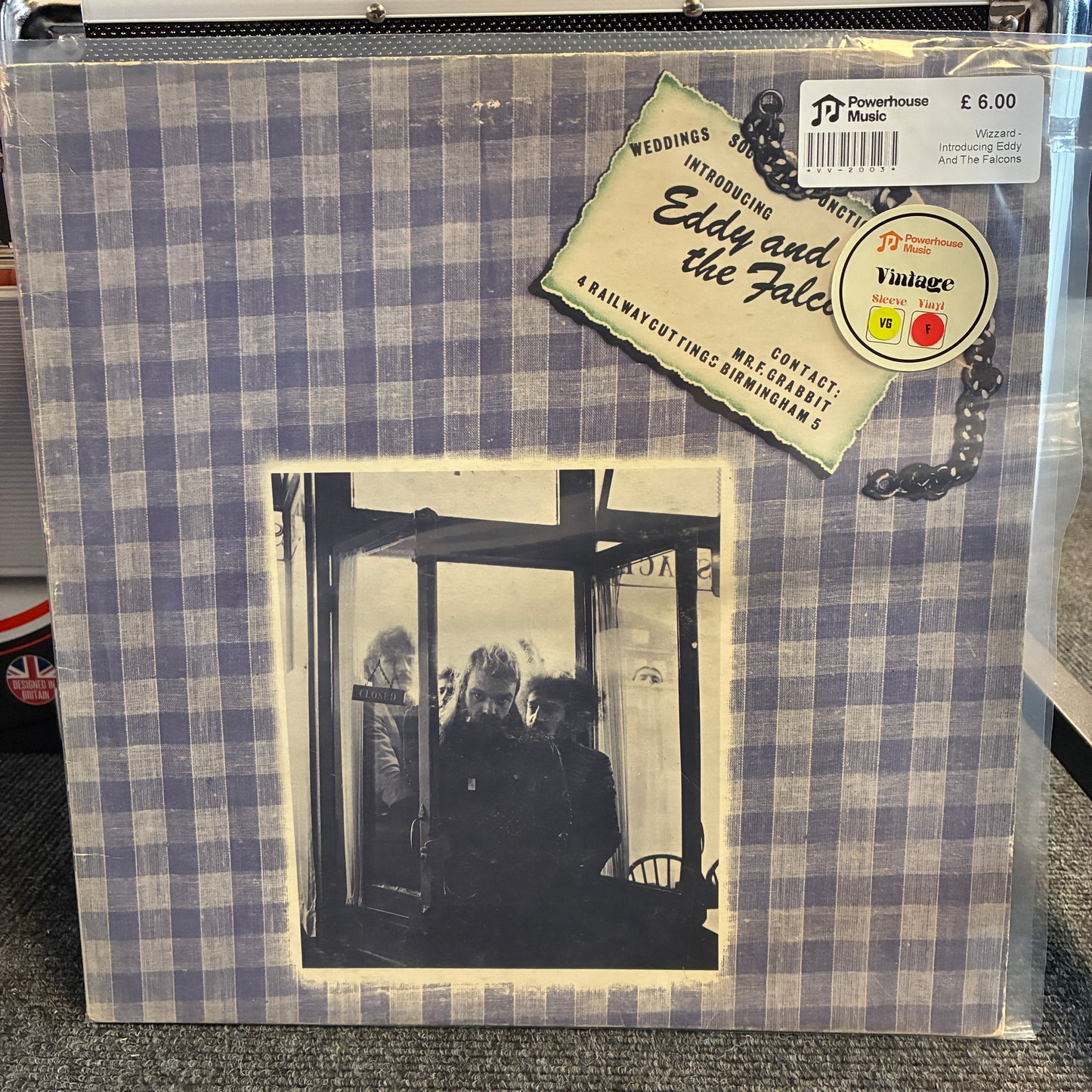 Wizzard - Introducing Eddy And The Falcons Vintage Vinyl LP A vinyl record sleeve for Eddy and the Fates' 'Weddings, Engagements and Affairs' on Powerhouse Records, featuring a blue and white gingham border and a black-and-white photograph of three people in a doorway, sealed in a clear plastic protective sleeve.