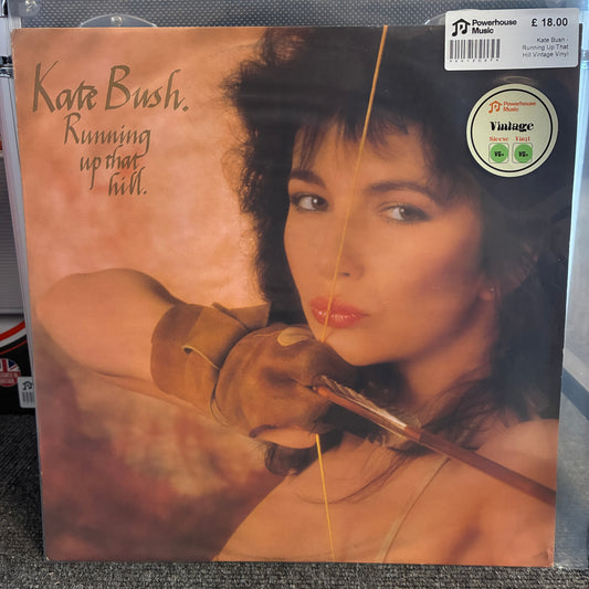 Kate Bush - Running Up That Hill Vintage Vinyl 12" Single A vinyl record sleeve for Kate Bush's 'Running up that hill.' is shown in a retail setting.