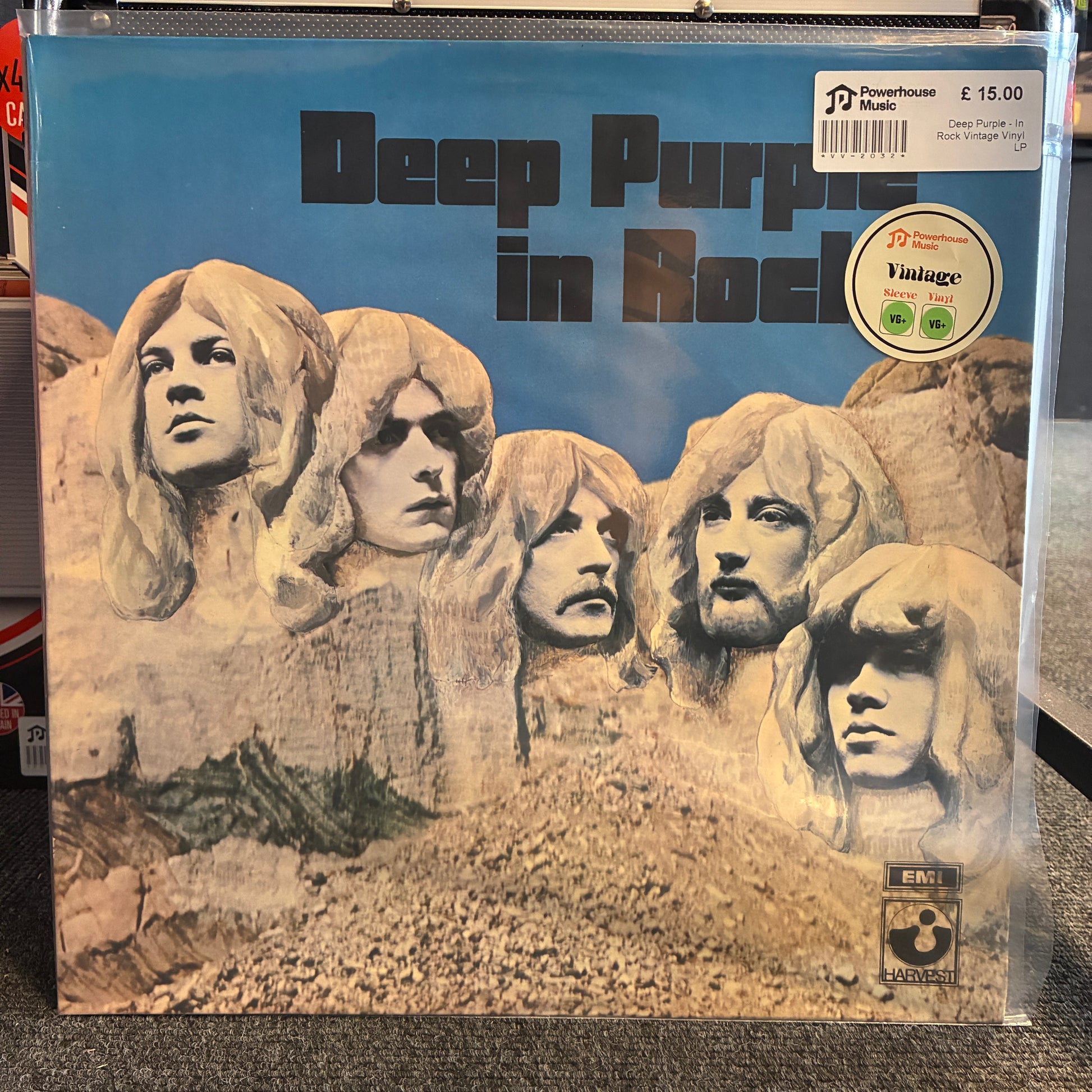 Deep Purple - In Rock Vintage Vinyl LP A vinyl record sleeve for Deep Purple's 'In Rock', featuring a sculpture-style portrait of the band members against a blue sky background. The sleeve is photographed inside a clear plastic protective case on a carpeted floor, with a price sticker and a 'Vintage' label visible.