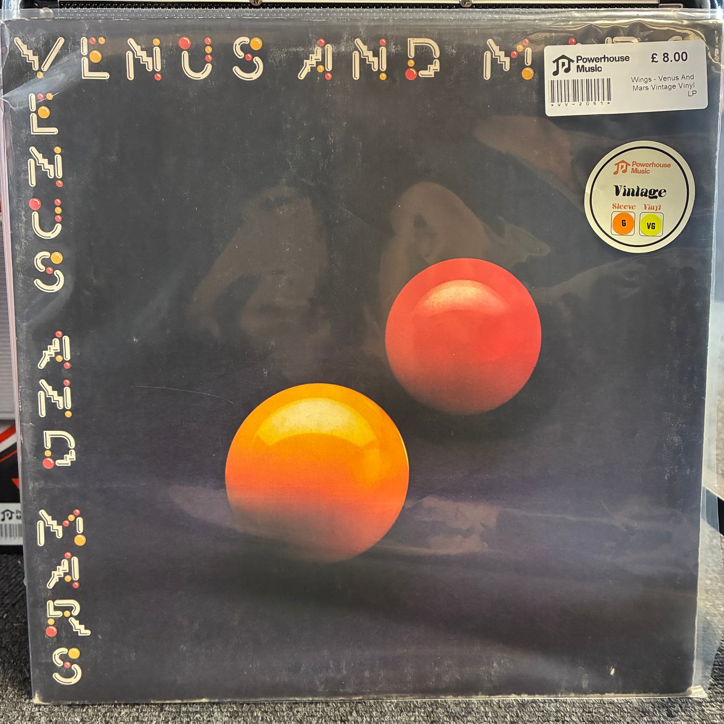 Wings - Venus And Mars Vintage Vinyl LP Venus and Mars vinyl record album cover by P/Dreamhouse, showing two orange-red spheres on a dark background with a price sticker and Vintage logo.