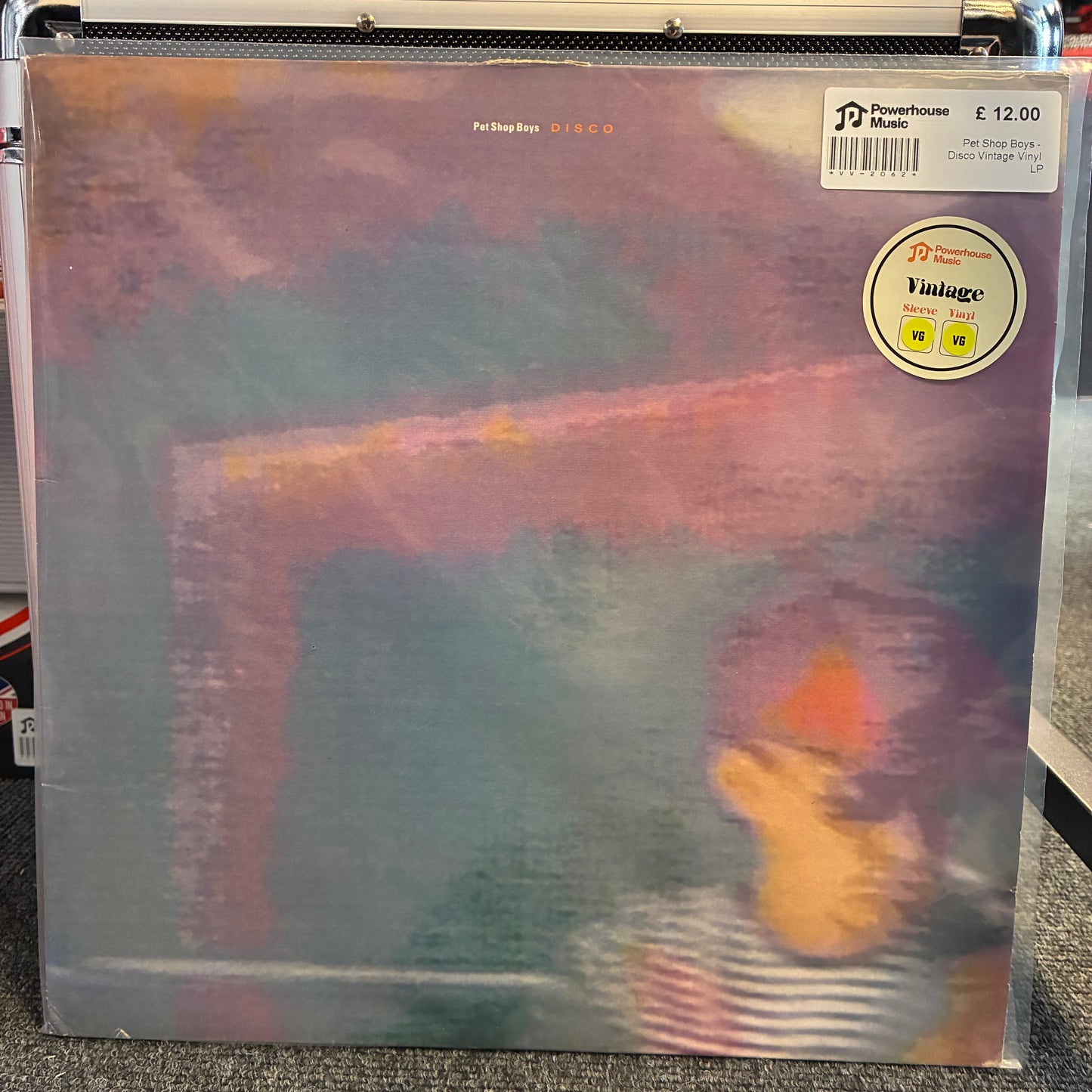 Pet Shop Boys - Disco Vintage Vinyl LP A vinyl record sleeve for Fela Tinlioy's 'DISCO' album, showing a colorful abstract cover with a blurred figure in the lower right. The sleeve is sealed in plastic and sits on a shelf, with a 'Powerhouse Music' sticker and barcode visible in the top right.