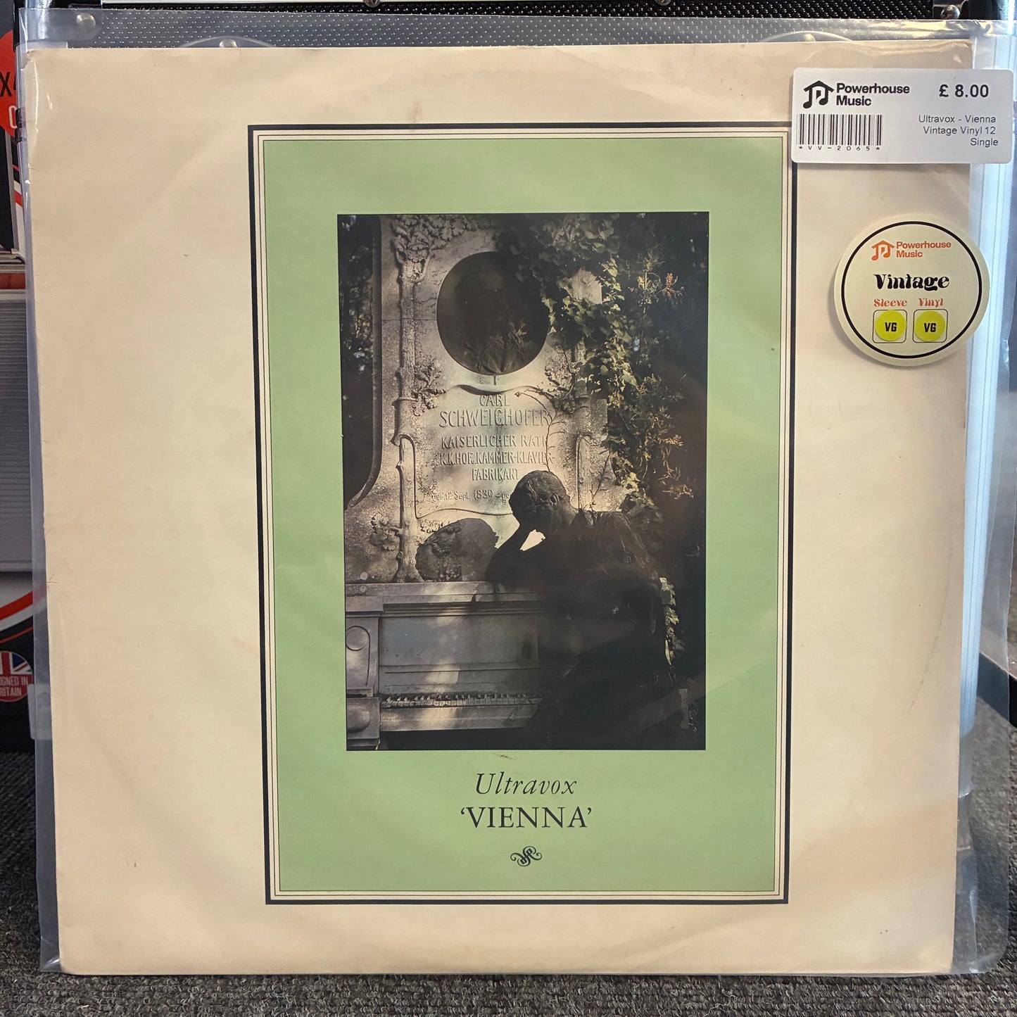 Ultravox - Vienna Vintage Vinyl 12" Single Ultravox 'Vienna' 12-inch vinyl record sleeve in a clear protective plastic case, featuring a cream-colored cover with a pale green border and a dark sepia-toned illustration of a classical statue.