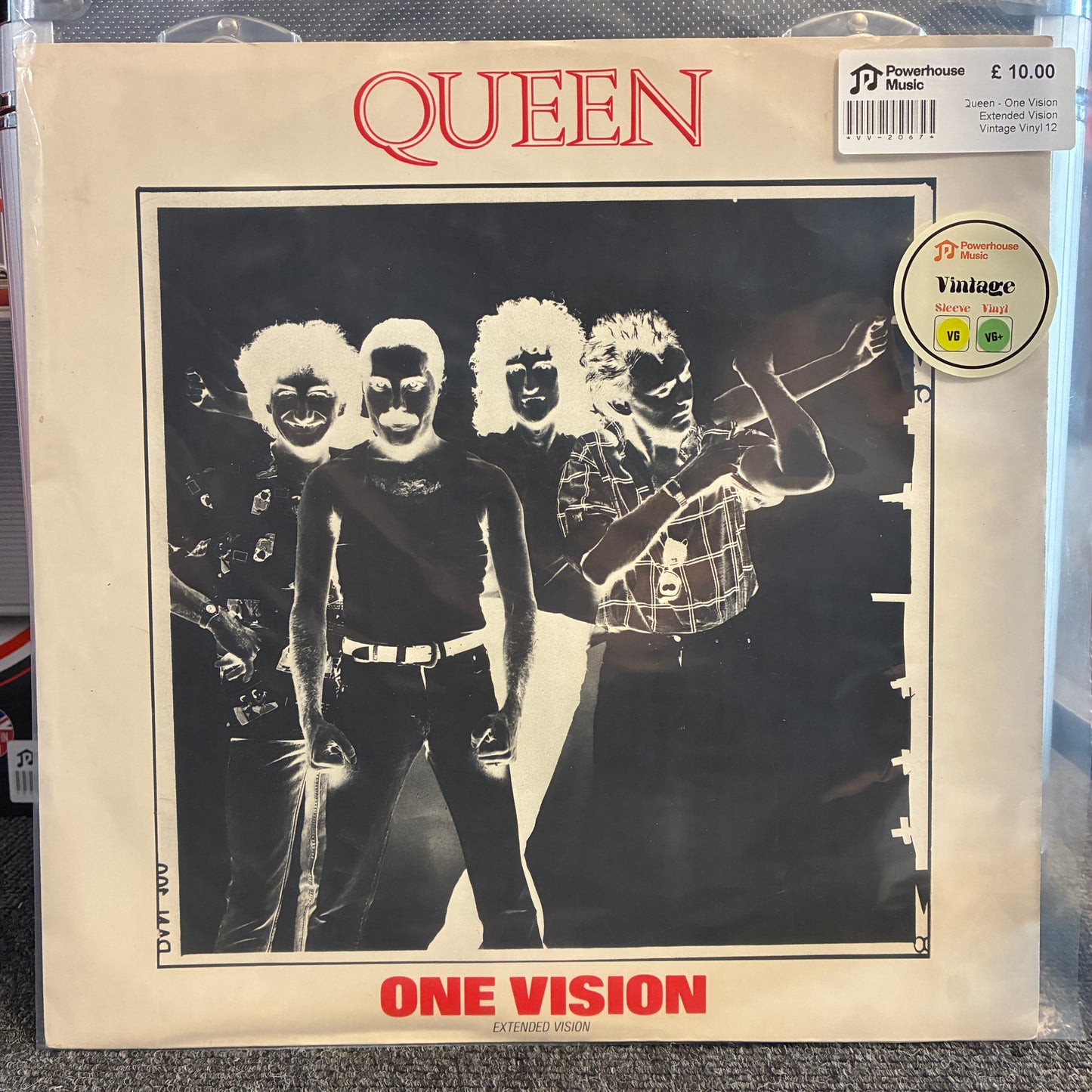 Queen - One Vision Extended Vision Vintage Vinyl 12" Single Queen 'One Vision' LP record sleeve in a clear plastic protective case, showing the band members in a black-and-white photo with red 'QUEEN' and 'ONE VISION' text on a cream background.