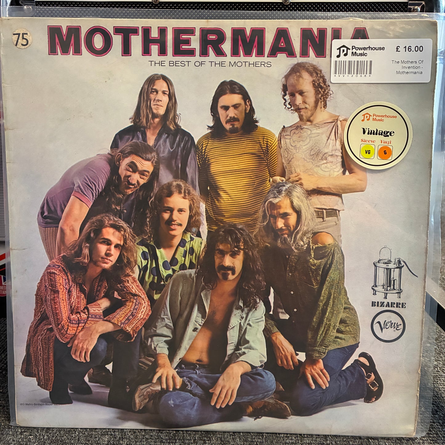 The Mothers Of Invention - Mothermania Vintage Vinyl LP The front cover of the vinyl record compilation album 'Mothermania: The Best of the Mothers' on a clear plastic sleeve, with the band members pictured on the cover.