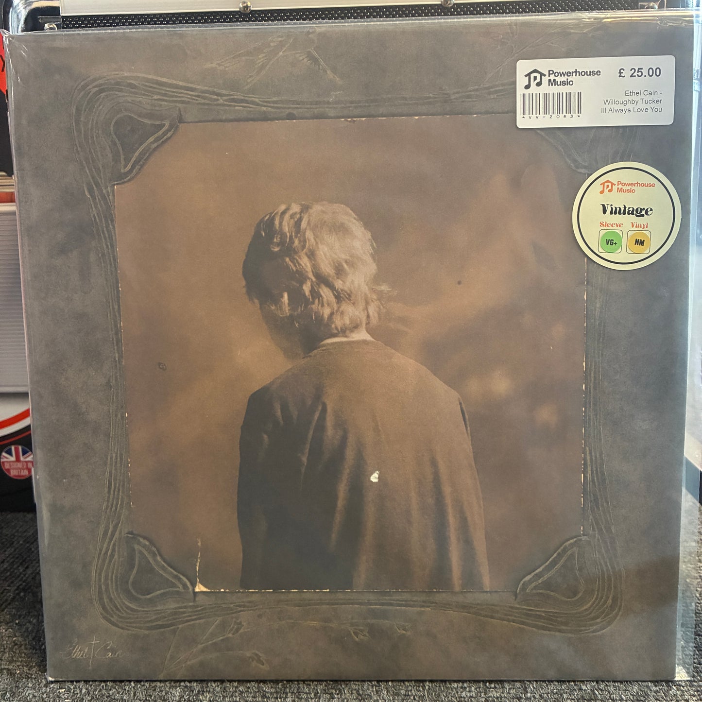 Ethel Cain - Willoughby Tucker Ill Always Love You Vintage Vinyl LP A vinyl record album in its original shrink wrap, featuring the back cover with a sepia-toned photograph of a person seen from behind. The cover has a decorative border and a white sticker at the top right from Powerhouse Music.
