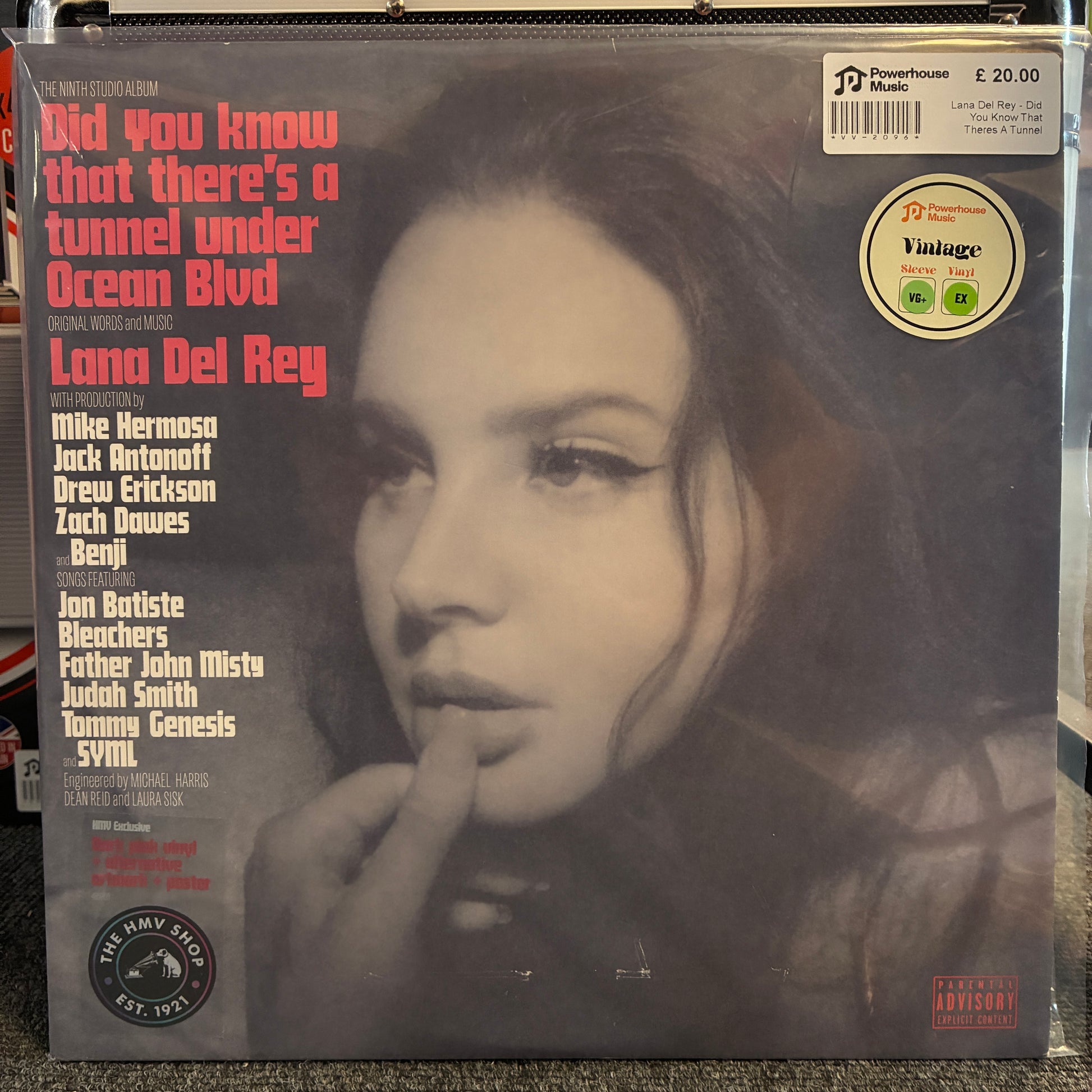 Lana Del Rey - Did You Know That Theres A Tunnel Under Ocean Blvd (Limited Edition Dark Pink) Vintage Vinyl LP A vinyl record sleeve for Lana Del Rey's album 'Did You Know That There's A Tunnel Under Ocean Blvd' on Powerhouse Records. The cover features a black-and-white close-up portrait of the artist, with pink and white text listing track titles and collaborators.