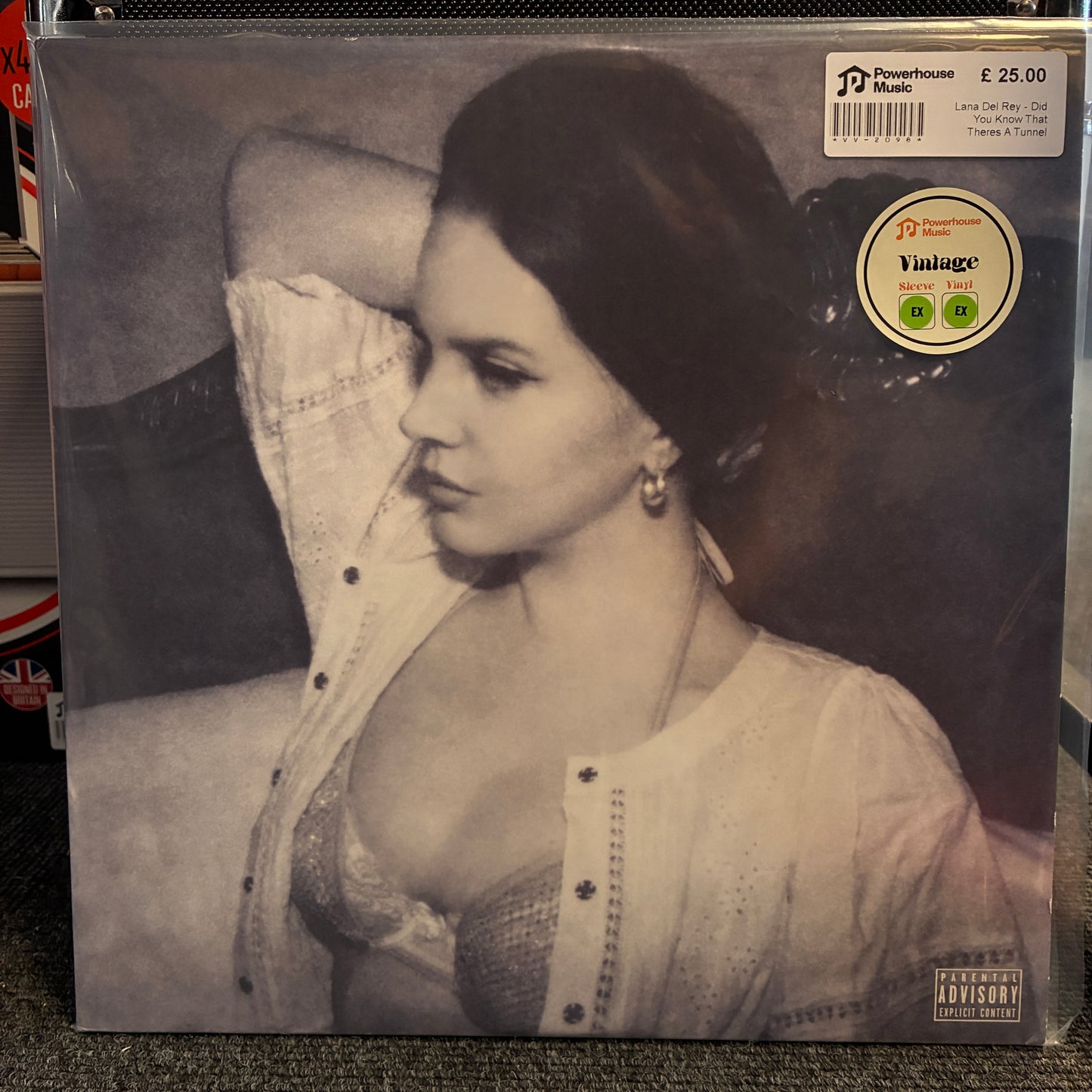 Lana Del Rey - Did You Know That Theres A Tunnel Under Ocean Blvd (Limited Edition White) Vintage Vinyl LP A vinyl record sleeve for Lana Del Rey's 'The Power of Love' on Powerhouse Records, featuring a black-and-white portrait of the artist. A 'Vintage' sticker is visible on the top right, and the record is photographed standing on a dark textured surface.