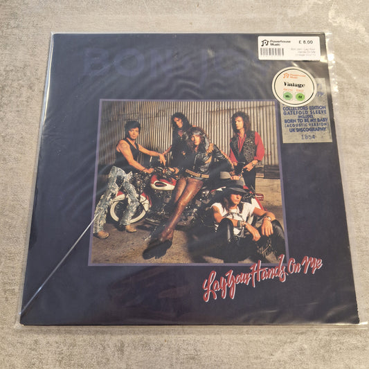 Bon Jovi - Lay Your Hands On Me Vintage Vinyl 12" Single Bon Jovi's 'The Power and the Glory' vinyl record album in its original shrink wrap, photographed on a gray textured floor. The cover is dark blue with the band's name in red script and a central photo of the four band members.