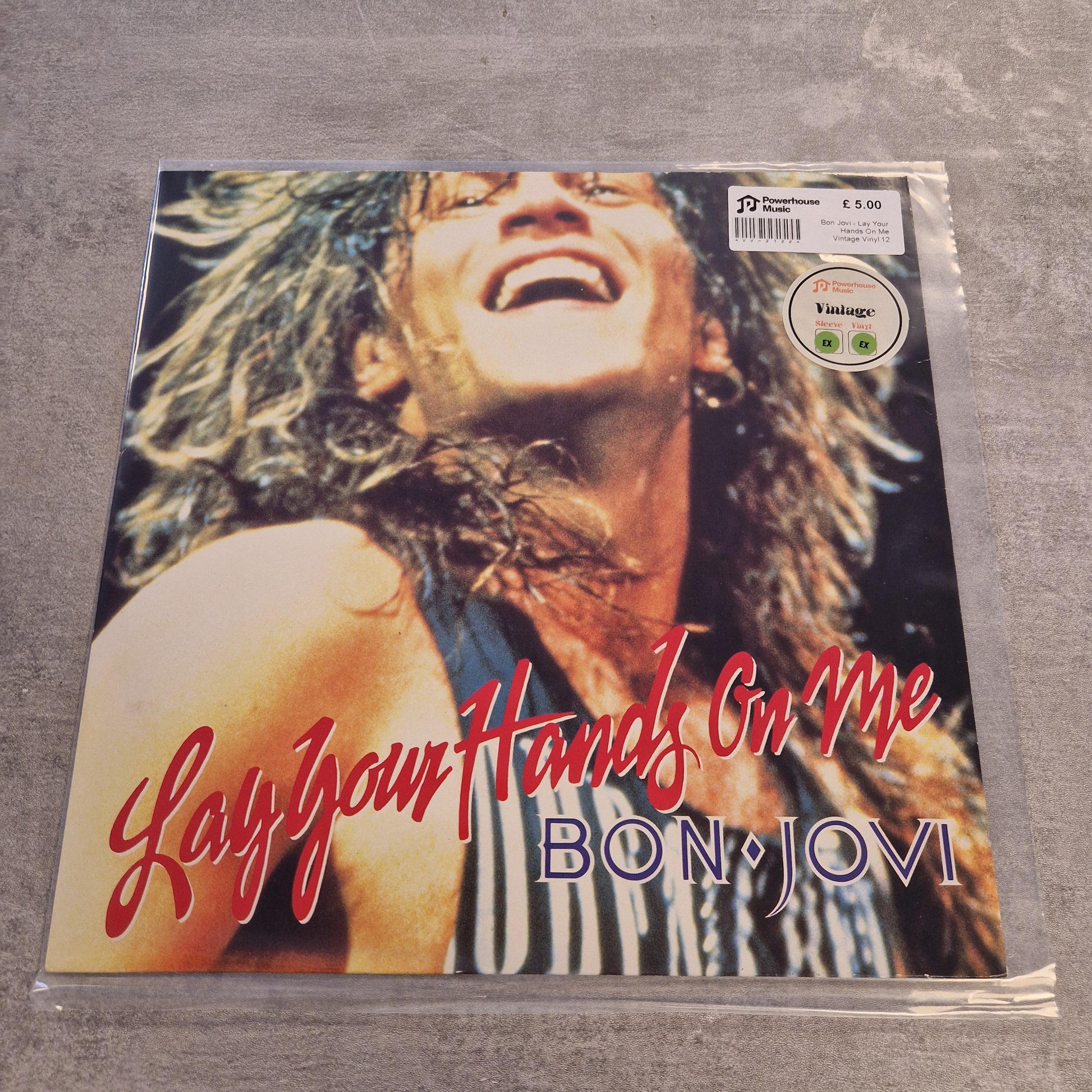 Bon Jovi - Lay Your Hands On Me Vintage Vinyl 12" Single Bon Jovi 'Lay Your Hands On Me' vinyl record sleeve in plastic shrink-wrap, photographed against a gray textured background.