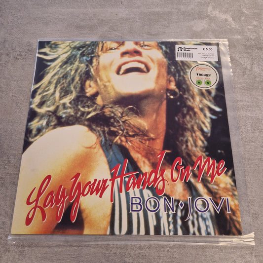 Bon Jovi - Lay Your Hands On Me Vintage Vinyl 12" Single Bon Jovi 'Lay Your Hands On Me' vinyl record sleeve in plastic shrink-wrap, photographed against a gray textured background.