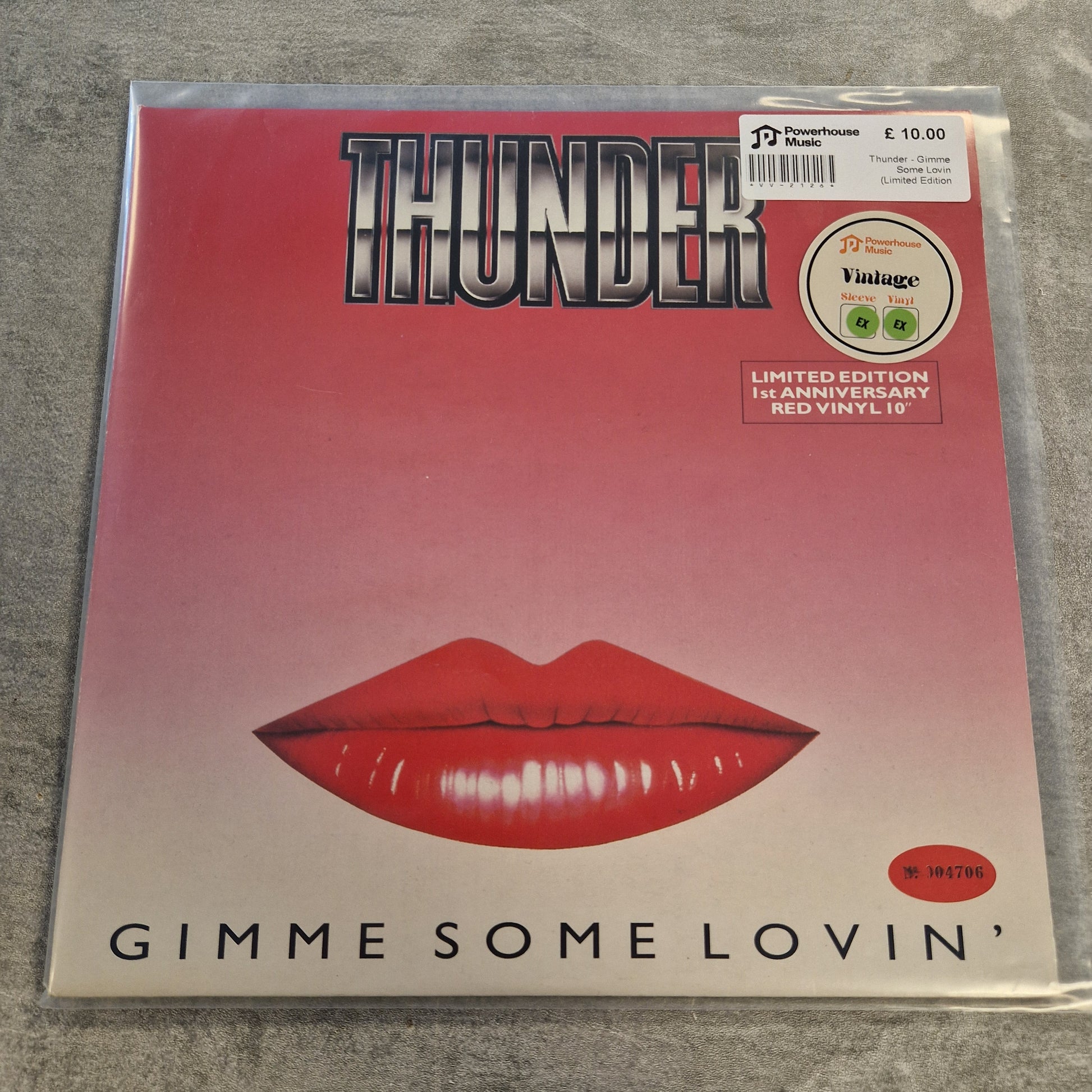 Thunder - Gimme Some Lovin (Limited Edition Red) Vintage Vinyl 10" Single A vinyl record sleeve for the album 'Gimme Some Lovin'' by Thunder, featuring a red lips graphic on a pink-to-white gradient background, photographed in a clear plastic sleeve on a gray textured surface.