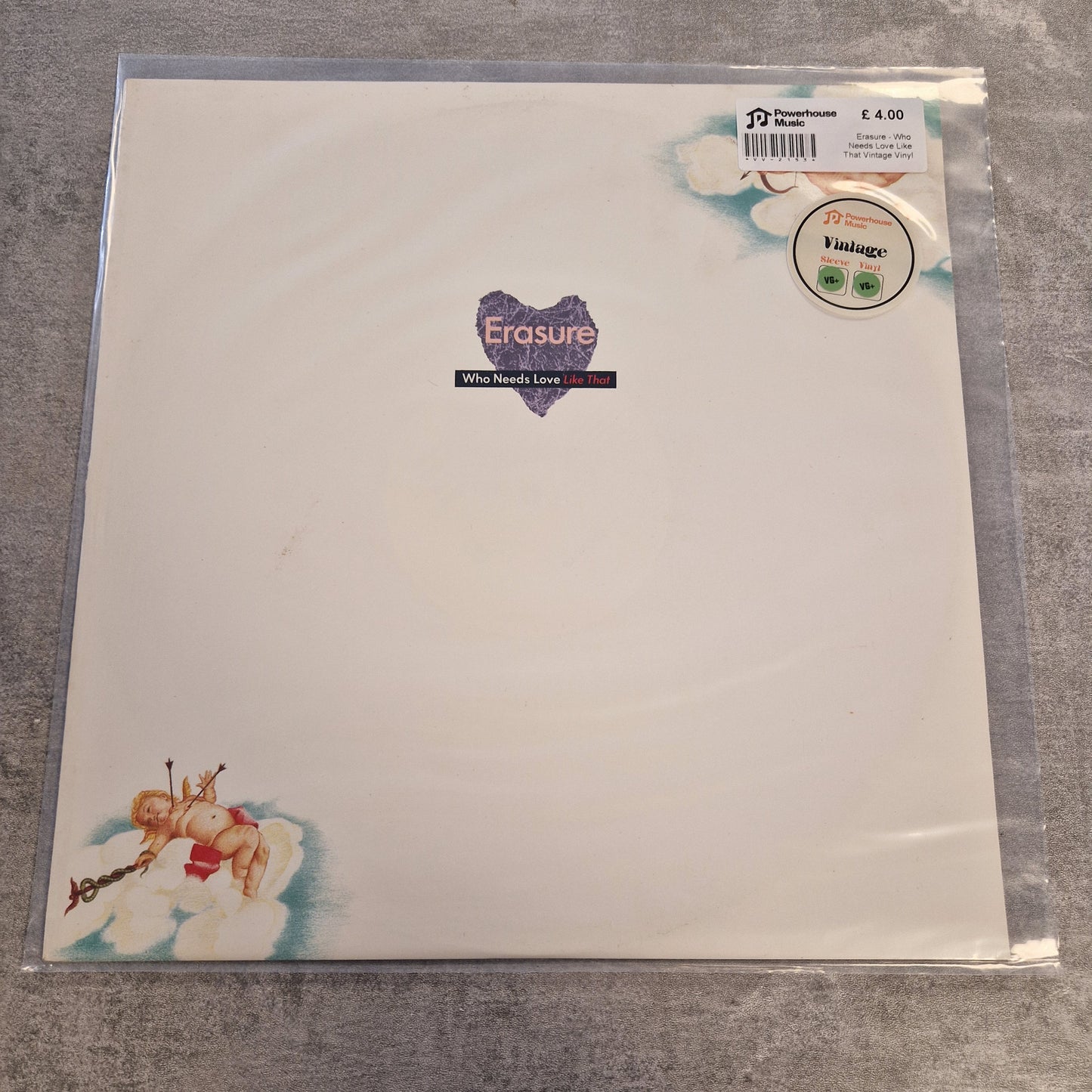 Erasure - Who Needs Love Like That Vintage Vinyl 12" Single A vinyl record sleeve for Erasure's 'All Around Love' 12-inch release, sealed in a clear plastic protective case. The sleeve features a clean white background with a purple heart-shaped logo in the center and cherub illustrations in the bottom-left corner.