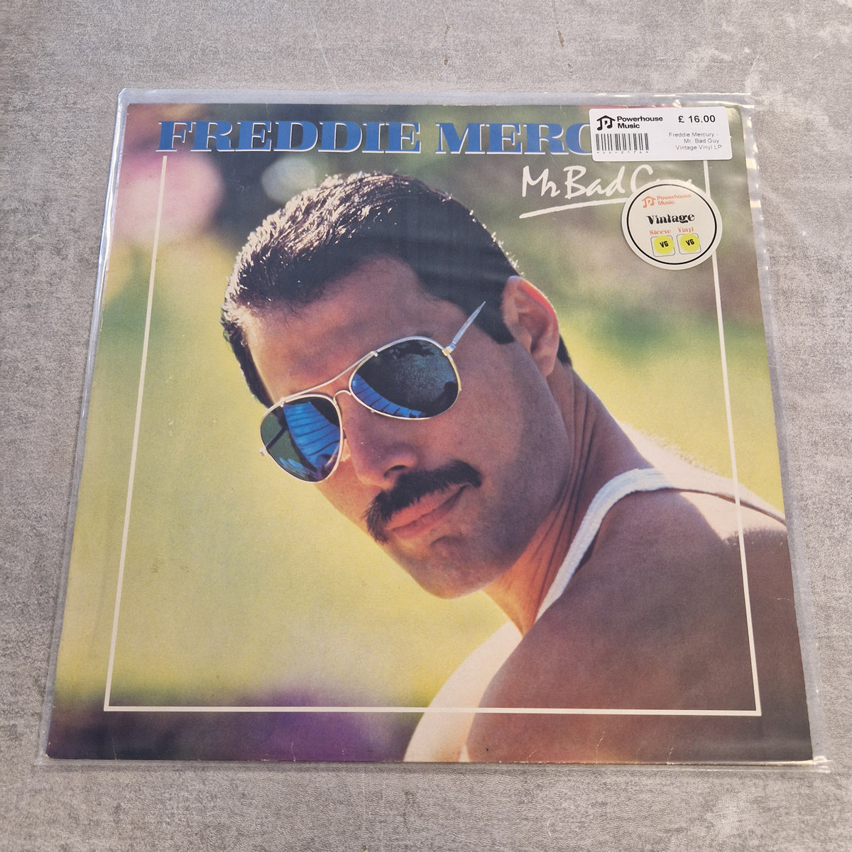 Freddie Mercury - Mr. Bad Guy Vintage Vinyl LP Freddie Mercury's 'Mr. Bad' vinyl record LP cover, sealed in a clear protective sleeve and photographed on a gray textured surface.