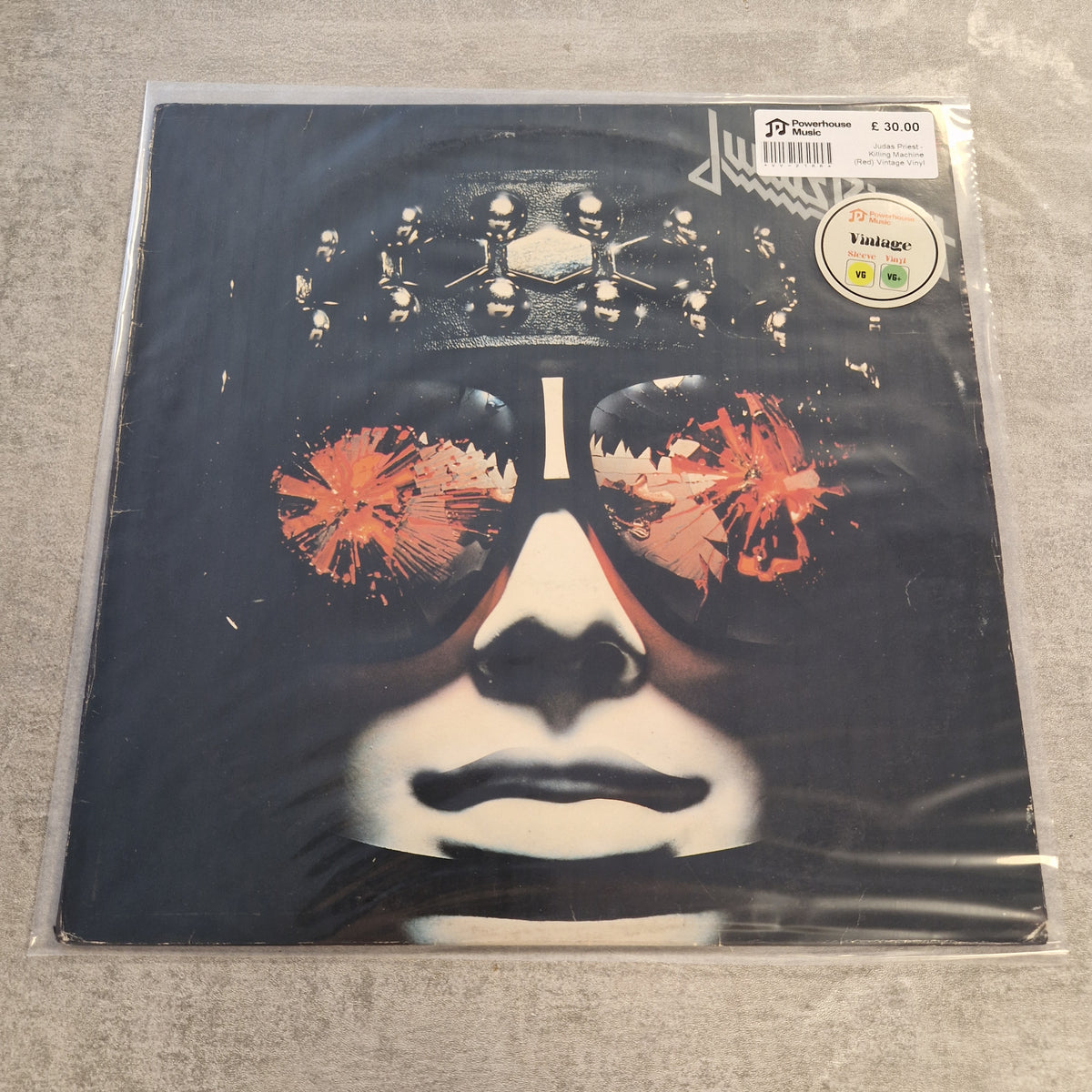 Judas Priest - Killing Machine (Red) Vintage Vinyl LP A vinyl record sleeve for Lou Reed's 'The House of Cards' on Vinted, sealed in a clear plastic protective sleeve. The cover art features a stylized black and white portrait of a face wearing a metallic crown, with orange-red abstract splatters in the eye area.