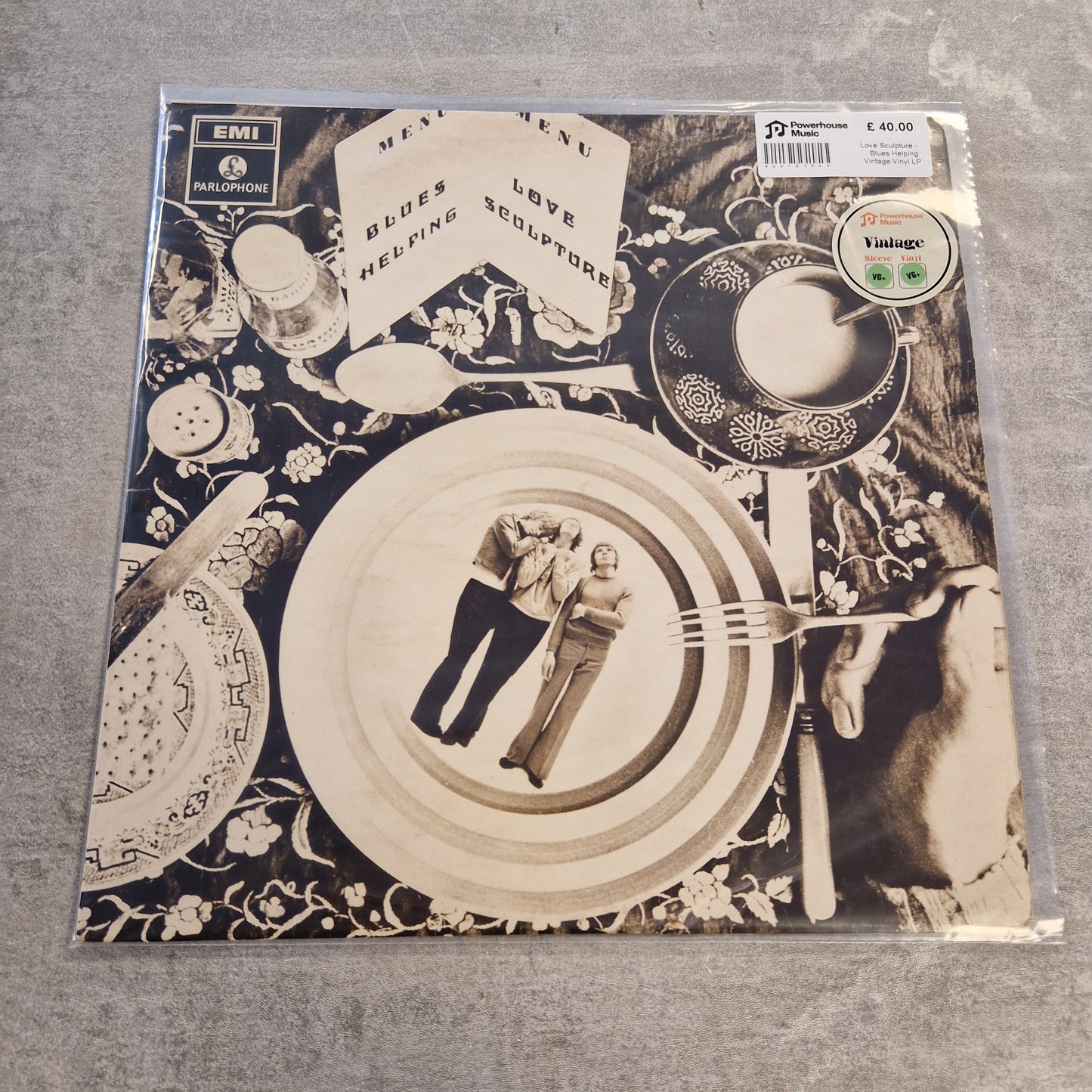 Love Sculpture - Blues Helping Vintage Vinyl LP A vinyl record sleeve for the band EMI's 'Blues, Love, Healing, Sculptors' on the Valhalla label, featuring a surreal black and white coffee table scene with plates, a teacup, and a hand holding a fork.