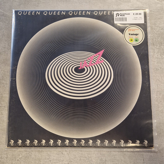 Queen - Jazz Vintage Vinyl LP A vinyl record sleeve for Queen's 'The Dreamy Album' is shown on a gray textured surface. The cover features a black background with a large white hypnotic spiral pattern and a pink '47' logo in the center.