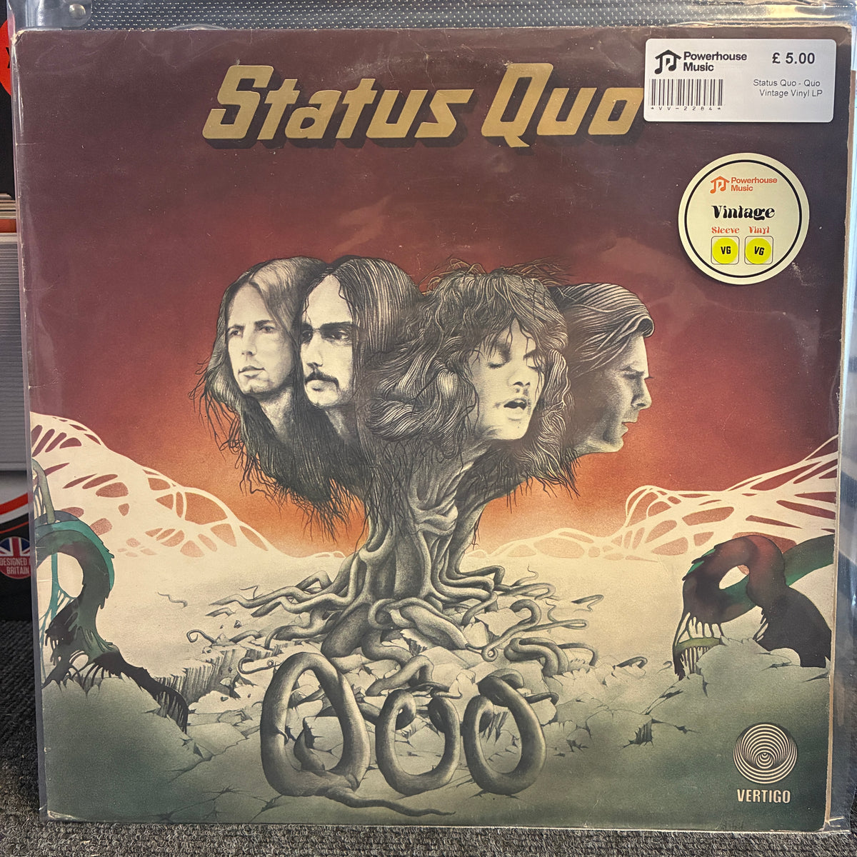 Status Quo - Quo Vintage Vinyl LP A vinyl record sleeve for Status Quo's 'Good News' album, showing the band members' faces as tree roots over a desert landscape. The sleeve is inside a clear plastic protective case, with a Warehouse 3 store sticker and a Vintage Vinyl sticker visible on the top right.