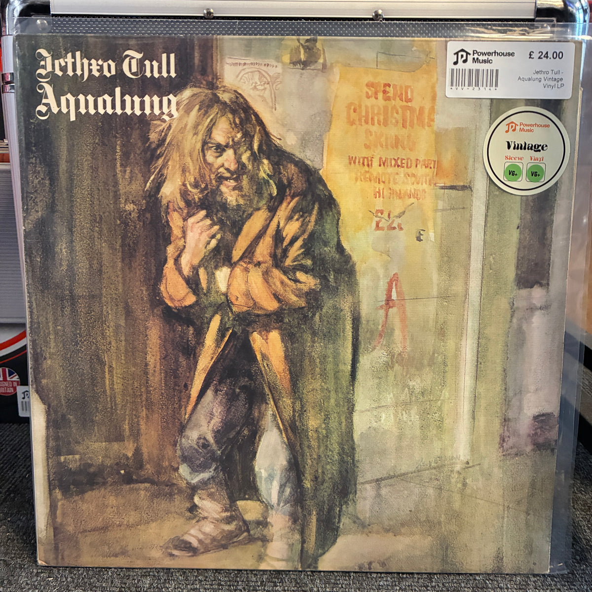 Jethro Tull - Aqualung Vintage Vinyl LP Aetho Tull - Aqnalung vinyl record sleeve shown in a clear plastic protective case. The cover features a painterly illustration of a man in a brown coat against a muted yellow and gray background.